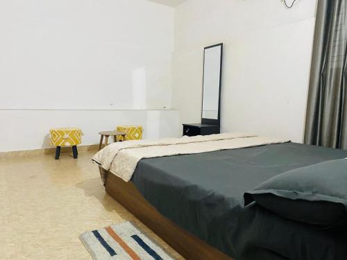 um quarto com uma cama, um espelho e uma mesa em Independent 2-Room with Kitchen Homestay em Dehradun