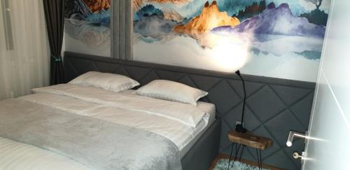 ein Schlafzimmer mit einem Bett mit einer Lampe in der Unterkunft Apartman Kaja (ski-to-door, Jahorina) in Jahorina