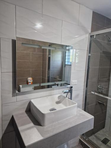 een badkamer met een wastafel en een spiegel bij Amharic in Kingston