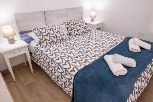 1 dormitorio con 1 cama y 2 toallas blancas en Casa Andrea Doria Arinaga, en Arinaga