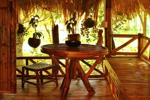 a wooden table and a chair on a porch at Banteay Srey Women's Only Traditional Spa and Homestay in Kampot