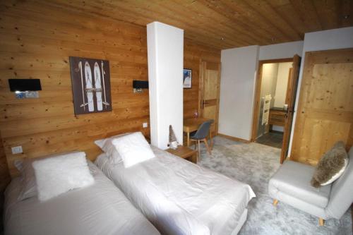 - une chambre avec un lit et une chaise dans l'établissement Le calme, le confort, la nature, skis aux pieds, à 15 kilomètres de Chamonix, à Vallorcine