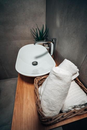 a white sink sitting on a table with towels at Jamy House in Habovka