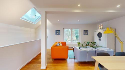 a living room with an orange chair and a couch at The Tile House - 2 bedroom property just south of Brussels in Sint-Genesius-Rode