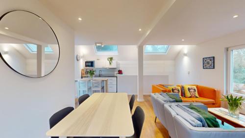 a living room with a table and a couch and a mirror at The Tile House - 2 bedroom property just south of Brussels in Sint-Genesius-Rode