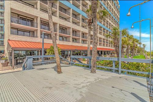 a building with palm trees in front of it at Couples Retreat 409 in Myrtle Beach