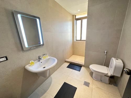 a bathroom with a sink and a toilet and a window at Saraya Al Joude in Irbid