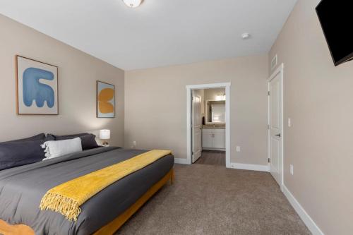 a bedroom with a king sized bed and a bathroom at Modern 2BR 2BA New Build Condo with Garage & Patio in Wyoming