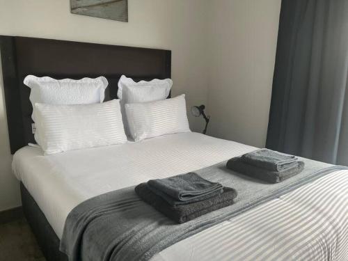 ein Bett mit zwei Handtüchern darüber in der Unterkunft 14 on Lawrence in Durban