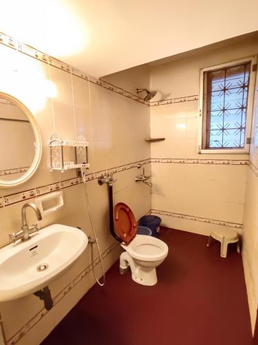 a bathroom with a toilet and a sink at Alor Elite Flats in Calangute