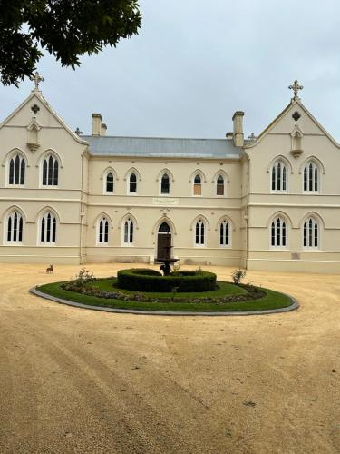 a large white building with a fountain in front of it at Convent at Koroit in Koroit