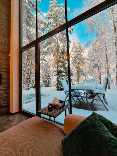 a living room with a view of the snow covered trees at Bobrowa Ostoja in Łukta
