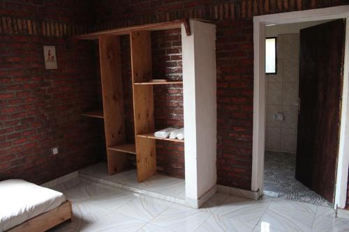 a room with a brick wall and a book shelf at KABA Local Rwandan Guesthouse Entire Property for you with Tour services in and out the city such as Safari's in Kigali
