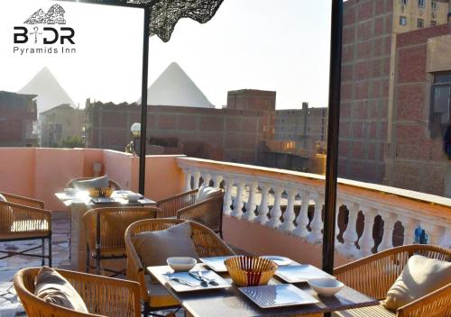 a restaurant with tables and chairs and a view of a city at Badr pyramids view in Cairo