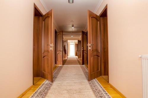 a hallway with wooden doors and a long corridor at Schale Centoriya in Mykulychyn
