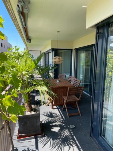 eine Terrasse mit einem Holztisch und Stühlen in der Unterkunft goodstay in Winterthur