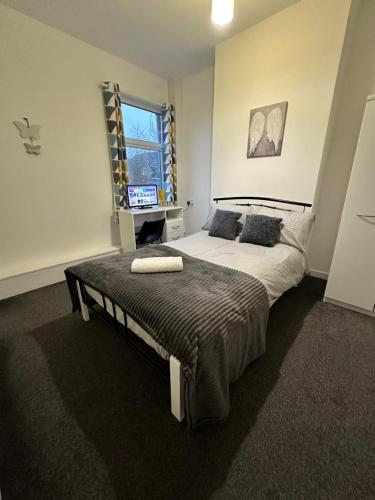 a bedroom with a large bed and a window at Lovely Town house Room 3 in Parkside