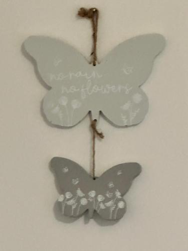 dos adornos de mariposa colgando de una pared en Lovely Town house Room 3, en Parkside