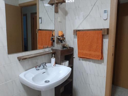 Un baño con un lavabo blanco y un espejo. en Casa Balta, en Ávila