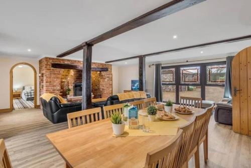 a dining room and living room with a table and chairs at amazing barn conversion with hot tub in North Walsham