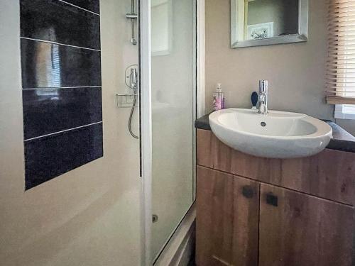 a bathroom with a sink and a shower at Beautiful 6 Berth Caravan With Decking At Valley Farm Holiday Park Ref 46736v in Great Clacton