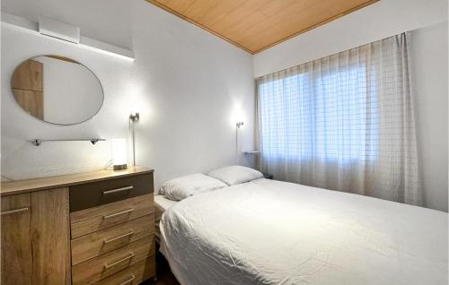 Schlafzimmer mit einem Bett, einem Spiegel und einem Fenster in der Unterkunft Amazing Apartment In De Haan With Wifi in De Haan