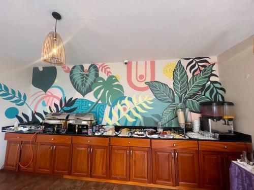a kitchen with a wall with plants on it at Arcadia Suites - Kampala in Kampala