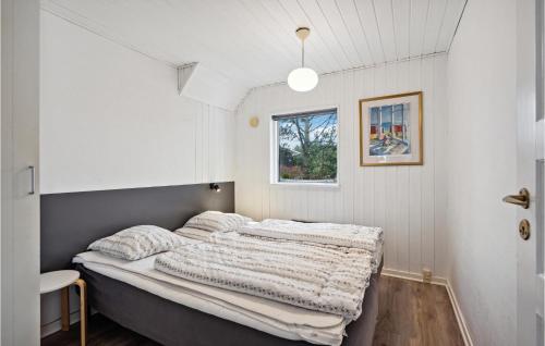 ein Schlafzimmer mit einem Bett in einem weißen Zimmer in der Unterkunft Gorgeous Home In Blvand With Sauna in Blåvand