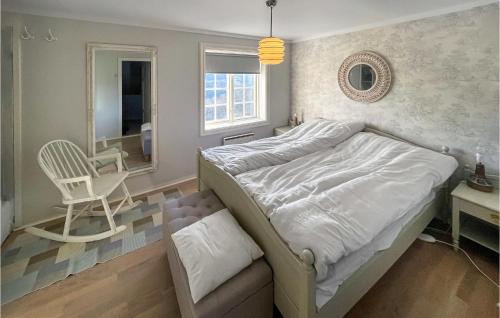een slaapkamer met een bed, een stoel en een spiegel bij Pet Friendly Home In Svorkmo With House A Panoramic View 