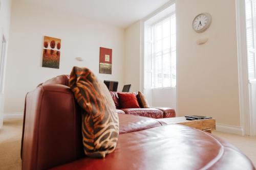 a living room with a couch with a pillow on it at Manor Court in Penzance