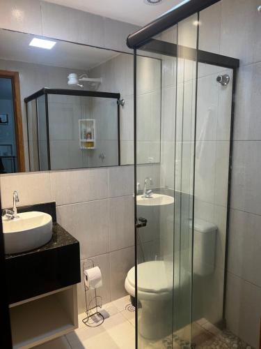 a bathroom with a glass shower and a toilet at Porto de Galinhas - Apartamento Flat Sea Residence 304 in Porto De Galinhas