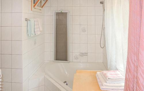 a white bathroom with a tub and a shower at Beautiful Apartment In Wildschnau With 3 Bedrooms And Internet in Auffach