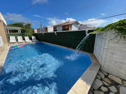 a swimming pool with a water fountain at Perequê Praia Hotel in Porto Belo