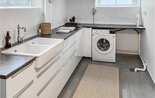 a white kitchen with a sink and a washing machine at 1 Bedroom Nice Home In Alingss in Alingsås