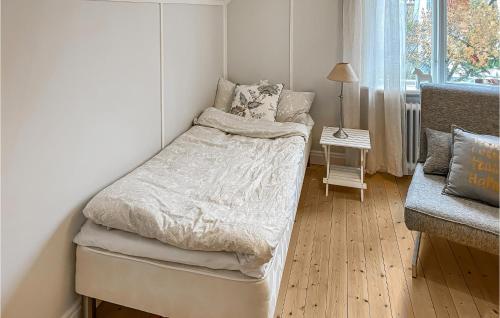 a small bedroom with a bed and a chair at 1 Bedroom Nice Home In Alingss in Alingsås