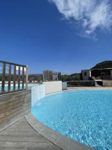 - une grande piscine sur une terrasse avec l'océan en arrière-plan dans l'établissement Appartement & Piscine Santa Giulia, à Porto-Vecchio