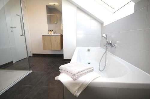 y baño con ducha, bañera y toallas. en Duplex Brussels airport 2 Chambre en Wezembeek-Oppem