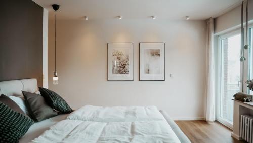 a bedroom with a bed and two pictures on the wall at Appartement Grünoase - zentrumsnah in Detmold