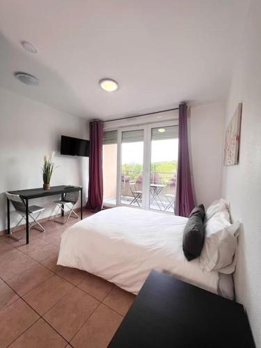 une chambre avec un lit, un bureau et une fenêtre dans l'établissement B210 Appartement DisneyLand Paris Parking et wifi, à Montévrain