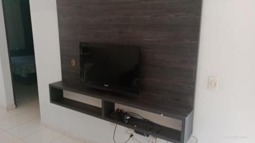 TV de pantalla plana sentada en un stand en una habitación en Casa Roma Cidade Ocidental, en Cidade Ocidental