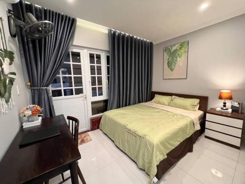 Schlafzimmer mit einem Bett, einem Schreibtisch und einem Fenster in der Unterkunft Homestay Phố Cổ Hải Phòng in Haiphong