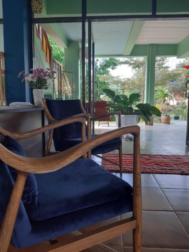 a wooden chair with a blue cushion in a room at Baan innto resort in Fang