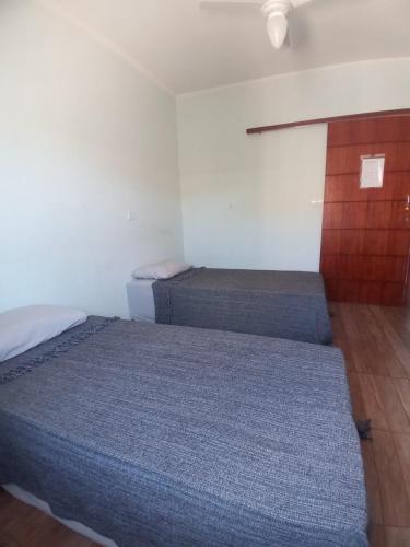 1 Schlafzimmer mit 2 Betten und einem Holzschrank in der Unterkunft Quarto Aconchego Solteiro in Artur Nogueira