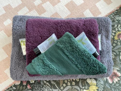 a purple and green towel with two toothbrushes at Double Bedroom in Sudbury Hill Wembley - 10 mins from Wembley Stadium in Harrow on the Hill