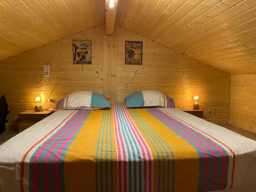 Saint-Laurent-du-JuraにあるChalet des Moineauxの木製の部屋に大型ベッドが備わるベッドルーム1室が備わります。
