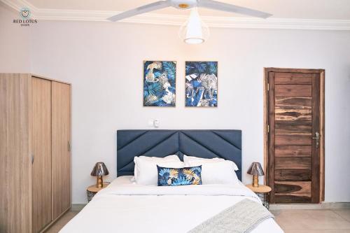 - une chambre avec un lit et deux peintures murales dans l'établissement Charming Rooftop Apartments with Great view & Free Strong Wi-Fi - 40percent Long-stay Disc- Red Lotus Oasis, à Accra