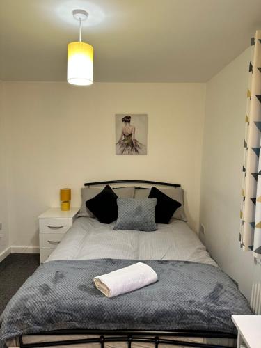 a bedroom with a bed with a blanket and a lamp at Lovely Town house Room 4 in Parkside