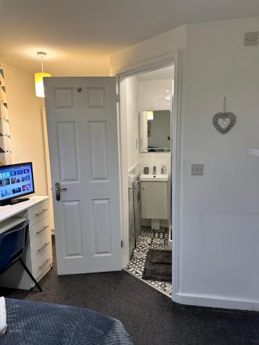 Schlafzimmer mit einer weißen Tür, die zu einem Bad führt in der Unterkunft Lovely Town house Room 4 in Parkside