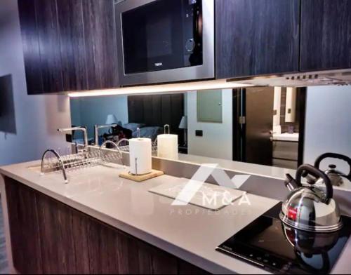 a kitchen with a counter top with a microwave at Hermoso Lofts Centro De Santiago in Santiago