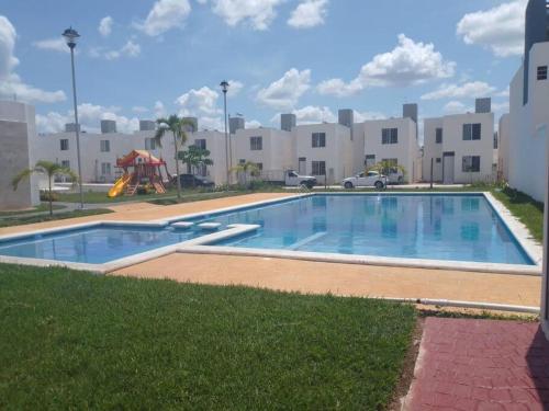 ein großer Pool mit Spielplatz vor einem Gebäude in der Unterkunft Casa Privada Palmas 10 con Alberca in Kanasín